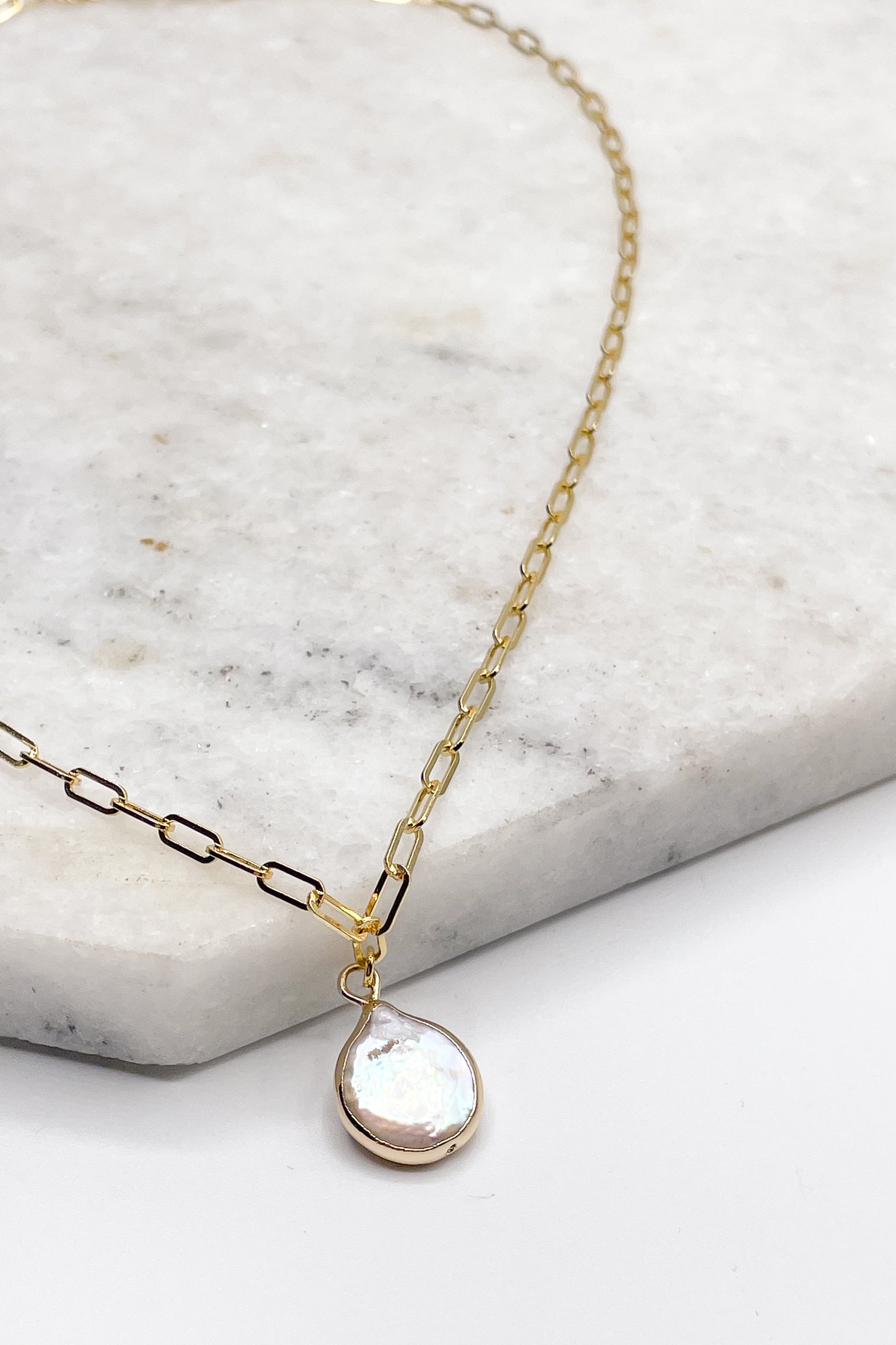 Close up of Piper Stone Gold Necklace. This is a gold necklace with a iridescent stone.