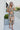 Full body front view of model wearing the Change of Heart Midi Dress, which features a satin material, a multi-colored floral print, a collared V surplice neckline, short cuffed sleeves, a tie waist, and a midi length