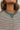 Close-up view of neckline; model is wearing the Hamptons Striped Sweatshirt, which features a cream colored material, a black stripe pattern, a rounded green ribbed neckline, and long sleeves with green ribbed cuffs.