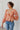 Front view of model wearing the Take Me Back Floral Top, which features a chiffon material, a multi-colored floral print, a V neckline with a tie detail, a front cut-out, long sleeves, and a smocked back