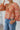 Close-up front view of model wearing the Take Me Back Floral Top, which features a chiffon material, a multi-colored floral print, a V neckline with a tie detail, a front cut-out, long sleeves, and a smocked back