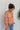 Side view of model wearing the Take Me Back Floral Top, which features a chiffon material, a multi-colored floral print, a V neckline with a tie detail, a front cut-out, long sleeves, and a smocked back