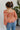 Back view of model wearing the Take Me Back Floral Top, which features a chiffon material, a multi-colored floral print, a V neckline with a tie detail, a front cut-out, long sleeves, and a smocked back