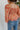 Back view of model wearing the Take Me Back Floral Top, which features a chiffon material, a multi-colored floral print, a V neckline with a tie detail, a front cut-out, long sleeves, and a smocked back