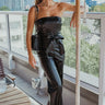 Front view of model wearing The Hailey Jumpsuit features black faux-leather, a sleeveless design, a straight neckline, a tie belt at the waist, a back zipper closure, and a straight leg fit.