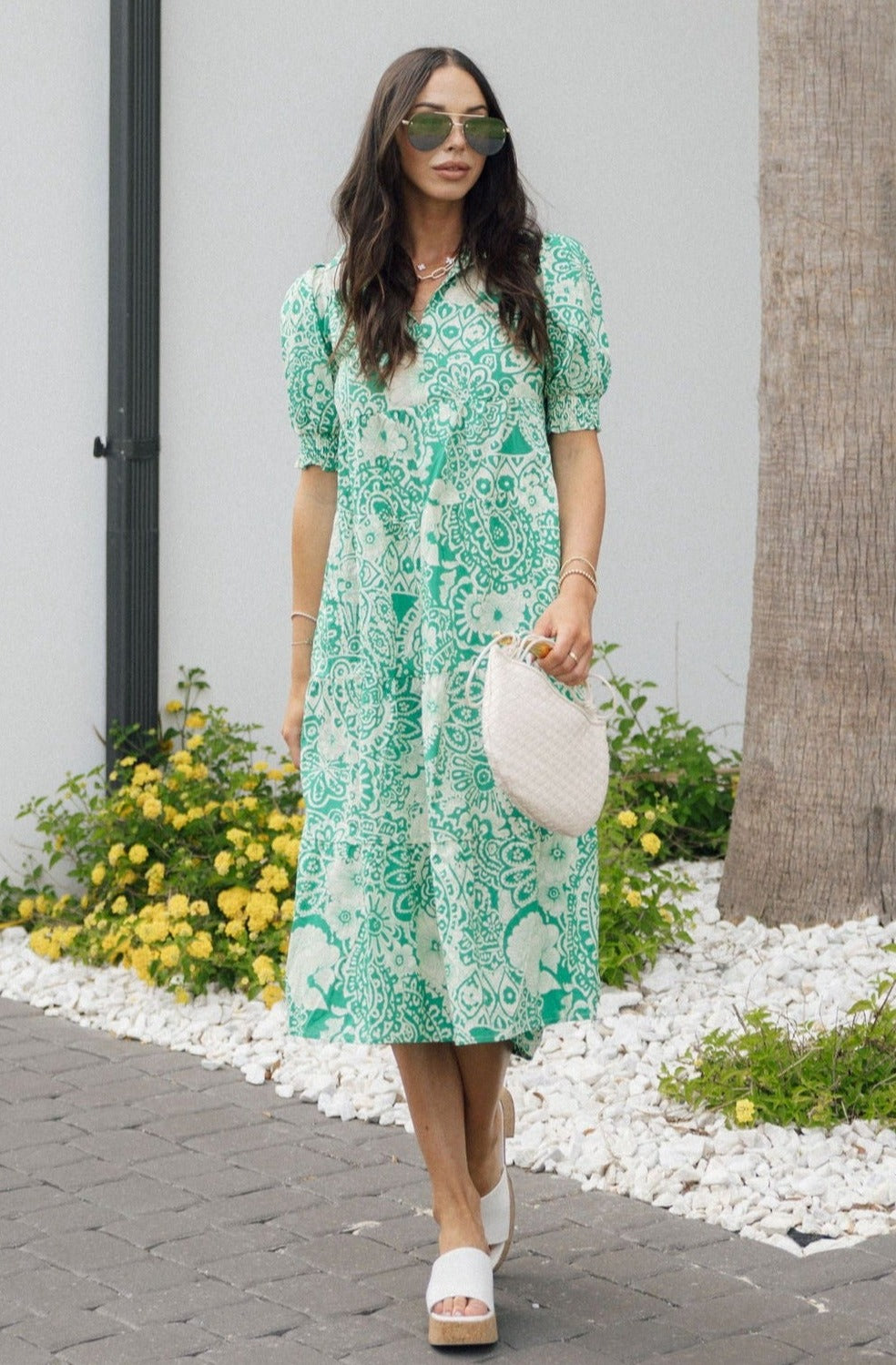 Full body view of female model wearing the Celeste Green & Cream Floral Paisley Midi Dress which features Green and Cream Floral Paisley Pattern, Midi Length, Tiered Body, V-Neckline with Collar and Short Puff Sleeves