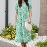 Full body view of female model wearing the Celeste Green & Cream Floral Paisley Midi Dress which features Green and Cream Floral Paisley Pattern, Midi Length, Tiered Body, V-Neckline with Collar and Short Puff Sleeves