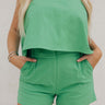 Front view of female model wearing the Jade Green Belt Loop Shorts which features Green Lightweight Fabric, Two Front Pockets, Front Zipper with Hook Closure, Belt Loops and Elastic Back Waistband