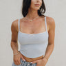 Front view of female model wearing the Amora Light Blue Lace Cropped Tank which features Light Blue Ribbed Fabric, White Lace Trim Details, Square Neckline, Adjustable Straps and Cropped Waist 