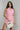 Front view of female model wearing the Palmer Pink Ruffle Halter Sleeveless Romper which features Pink Lightweight Fabric, Pink Shorts Lining, Surplice Neckline with Halter Neck Ties, Ruffle Hem Details, Open Back and Back Zipper with Hook Closure