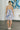 Full body back view of female model wearing the Payton Blue & Peach Floral Mini Dress which features Blue, Peach, Tan and Periwinkle Lightweight Fabric, Floral Pattern, Flare Hem Skirt, Mini Length, Scoop Neckline and Adjustable Straps
