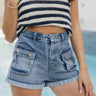 Front view of female model wearing the Rowyn Washed Denim Buttoned Pockets Shorts which features Medium Wash Denim Fabric, Folded Hem, Two Buttoned Front Pockets, Two Back Pockets, Front Zipper with Button Closure and Belt Loops