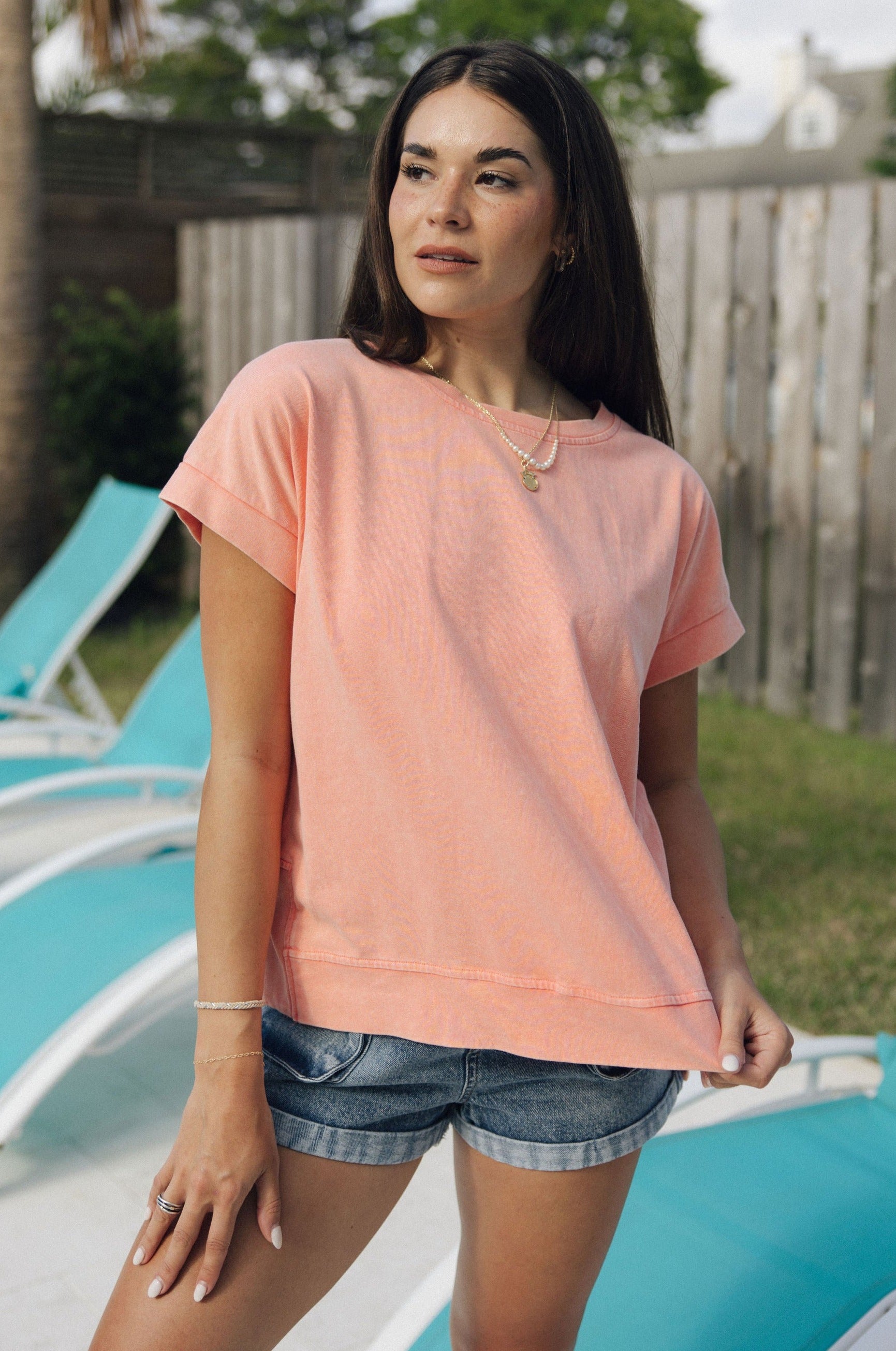 Front view of female model wearing the Jane Peach Short Sleeve Top which features Peach Cotton Fabric, Slits on each side, Short Sleeves and Round Neckline