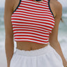 Close-up front view of female model wearing the Felicity Red, White, & Blue Striped Tank Top that has red and white horizontal stripes, navy trim, a cropped waist, and thick straps. Worn with white skirt.
