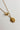 Close-up image of the Alexandra Gold Medallion Necklace against a white background. Necklace has gold chain with toggle closure and gold circle medallion with side profile of a gladiator.