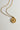 Image shows close-up of the Celeste Gold Star Medallion Necklace against a white background. Necklace has gold chain with circle medallion which has an 8 point star in the center.