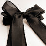 Close up view of the Harper Sheer Hair Bow Barrette in Black which features black sheer fabric, textured trim details, triple bow with a french barrette clip.