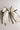 Flat lay view of Felicity Hair Bow Barrette in Ivory/Black which features  ivory fabric with black fabric trim, double bow with a french barrette clip