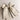 Flat lay view of Felicity Hair Bow Barrette in Ivory/Black which features ivory fabric with black fabric trim, double bow with a french barrette clip