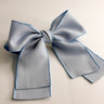 Flat lay view of Felicity Hair Bow Barrette in Baby Blue which features baby blue fabric, double bow with a french barrette clip