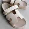 Front view of the Jade Strap Sandal in Ivory which features ivory leather fabric, slide-on style, H-shaped strap, adjustable velcro strap and round toe.