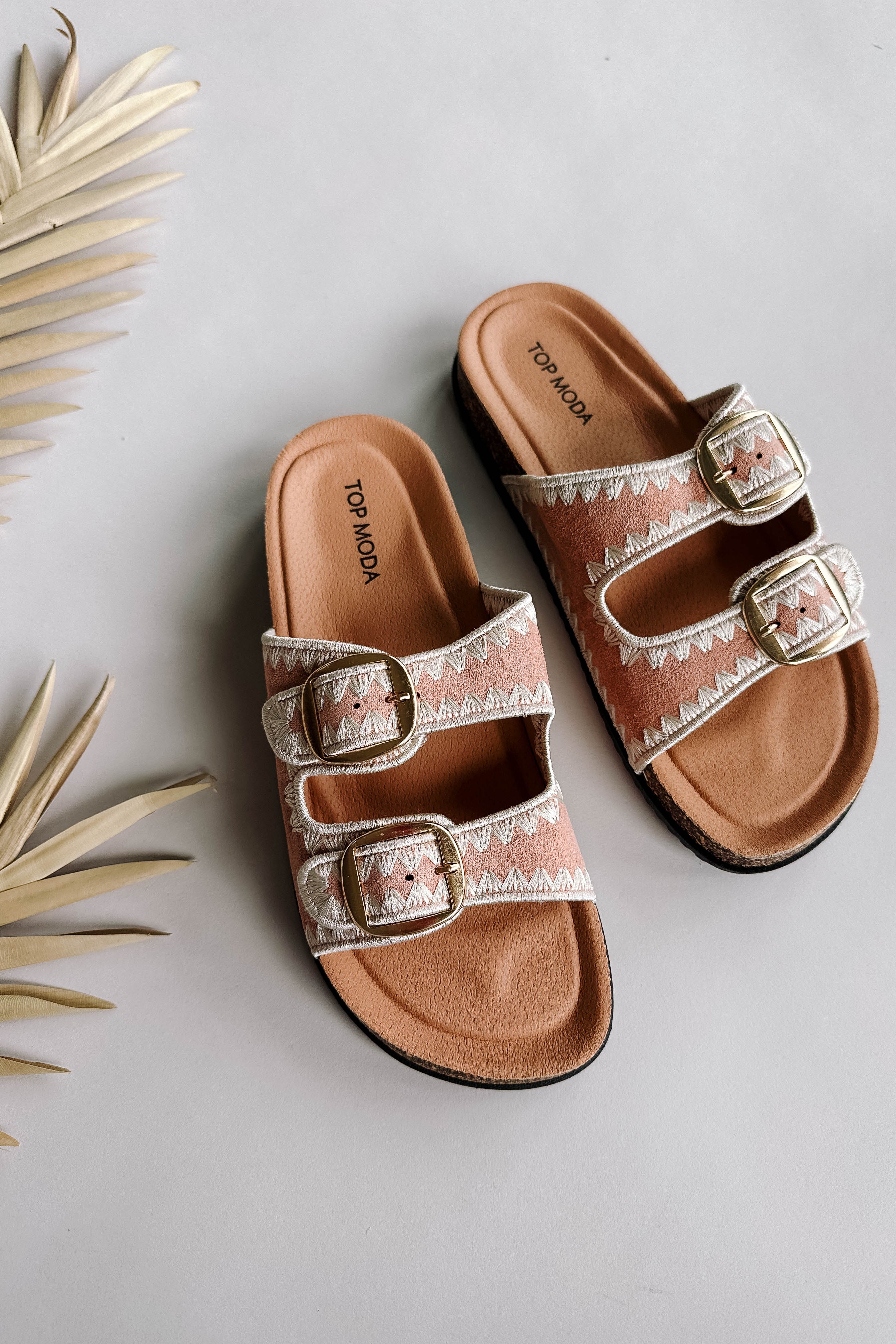 Ariel view of the Luca Sandal in Blush which features blush fabric, cream geometric trim design, two adjustable straps, gold buckles and slide-on style.