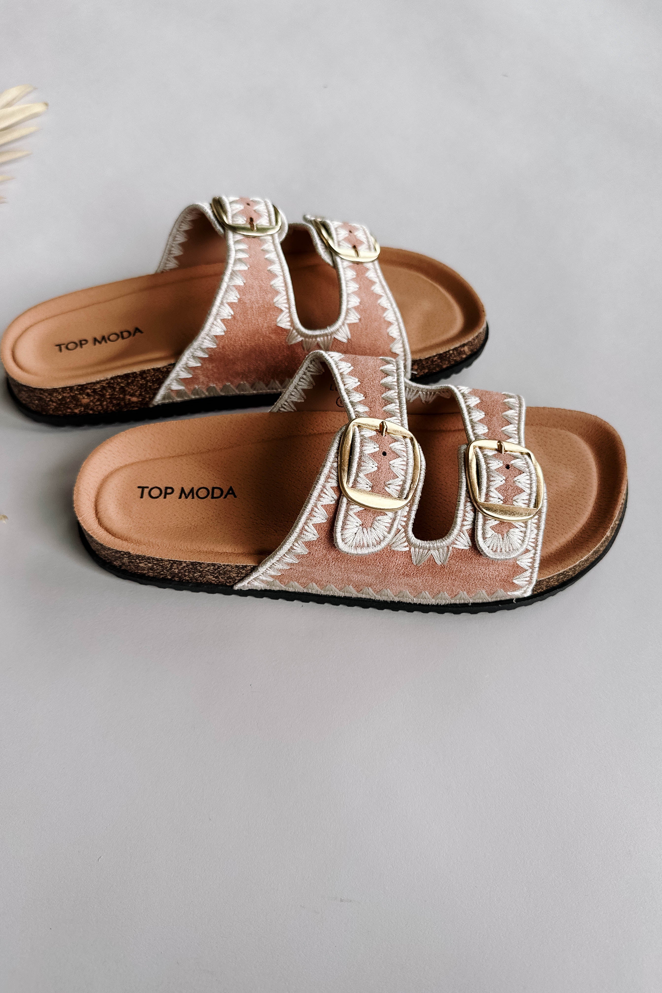 Side view of the Luca Sandal in Blush which features blush fabric, cream geometric trim design, two adjustable straps, gold buckles and slide-on style.