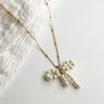 Close up view of the Mia Gold & Pearl Bow Necklace which features adjustable gold chain link with pearl bow attachment