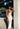 Full body view of female model wearing the Franceska Taupe Ombre Satin Midi Dress which features Brown Ombre Satin Fabric, Midi Length, Sleeveless, Black Thigh Length Lining and Cowl Neckline 