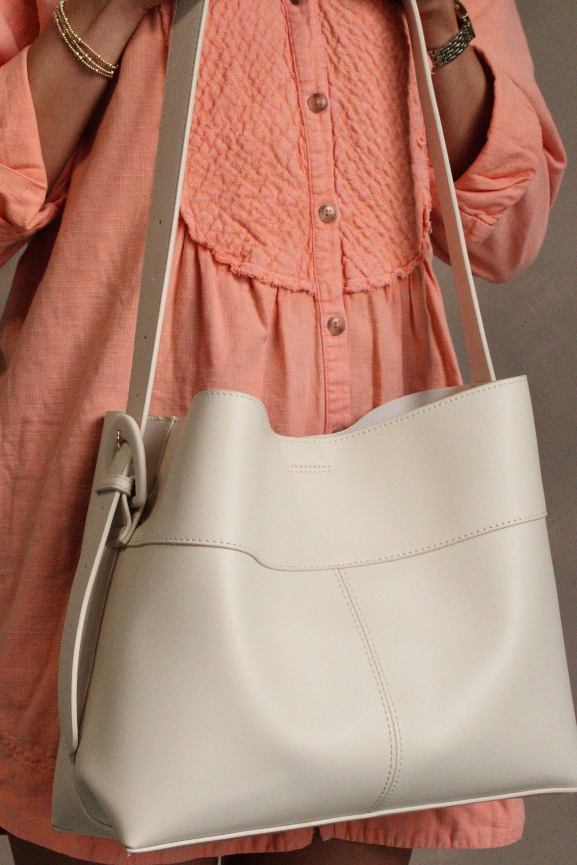 Rory Cream Faux Leather Shoulder Purse - front view of model holding