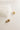 Close up detailed view of the Grace Gold Cross Stud Earring which features mini gold, open cross shaped huggies with hobnail design.