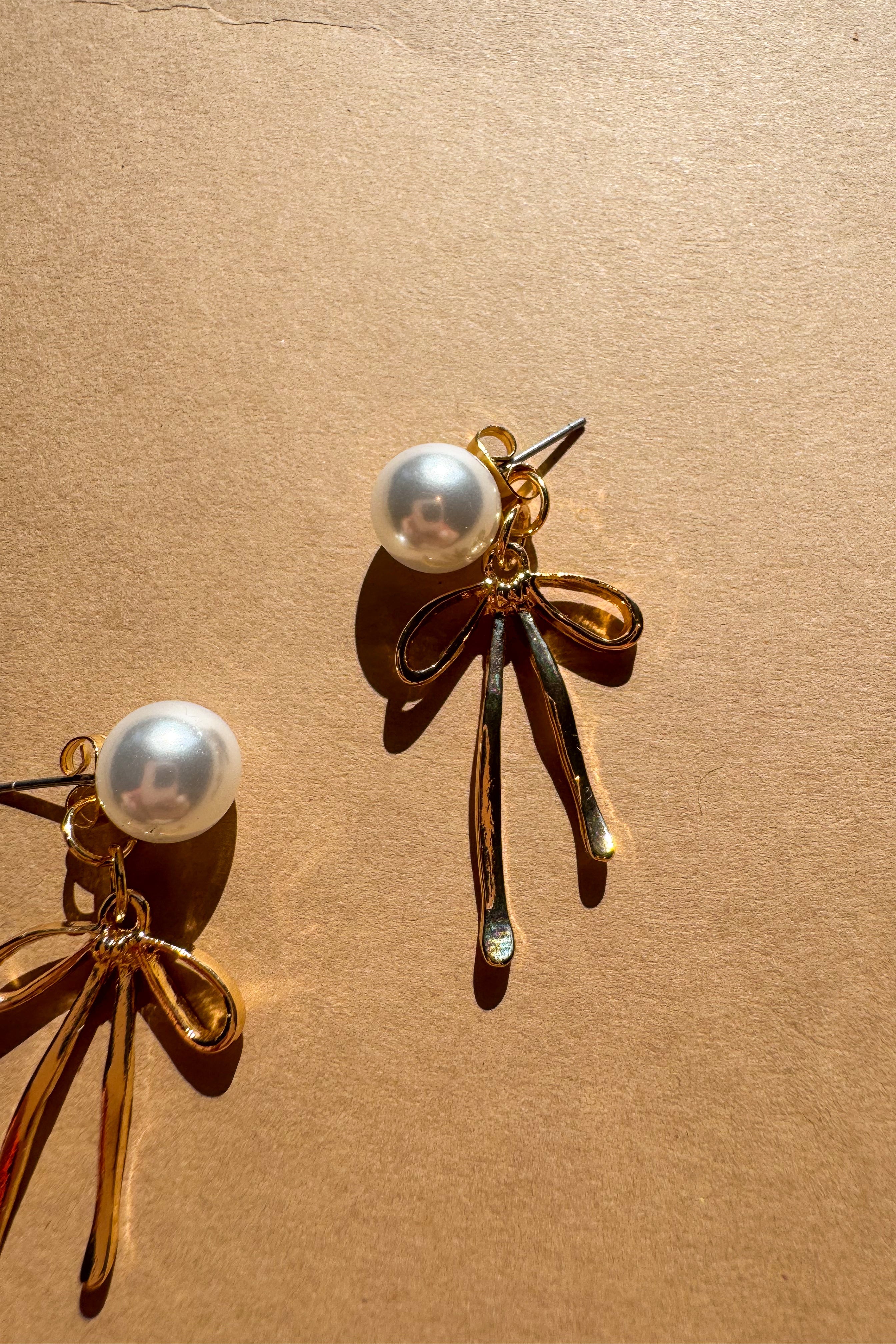 Vanessa Gold Bow & Pearl Earrings - flat lay close up view