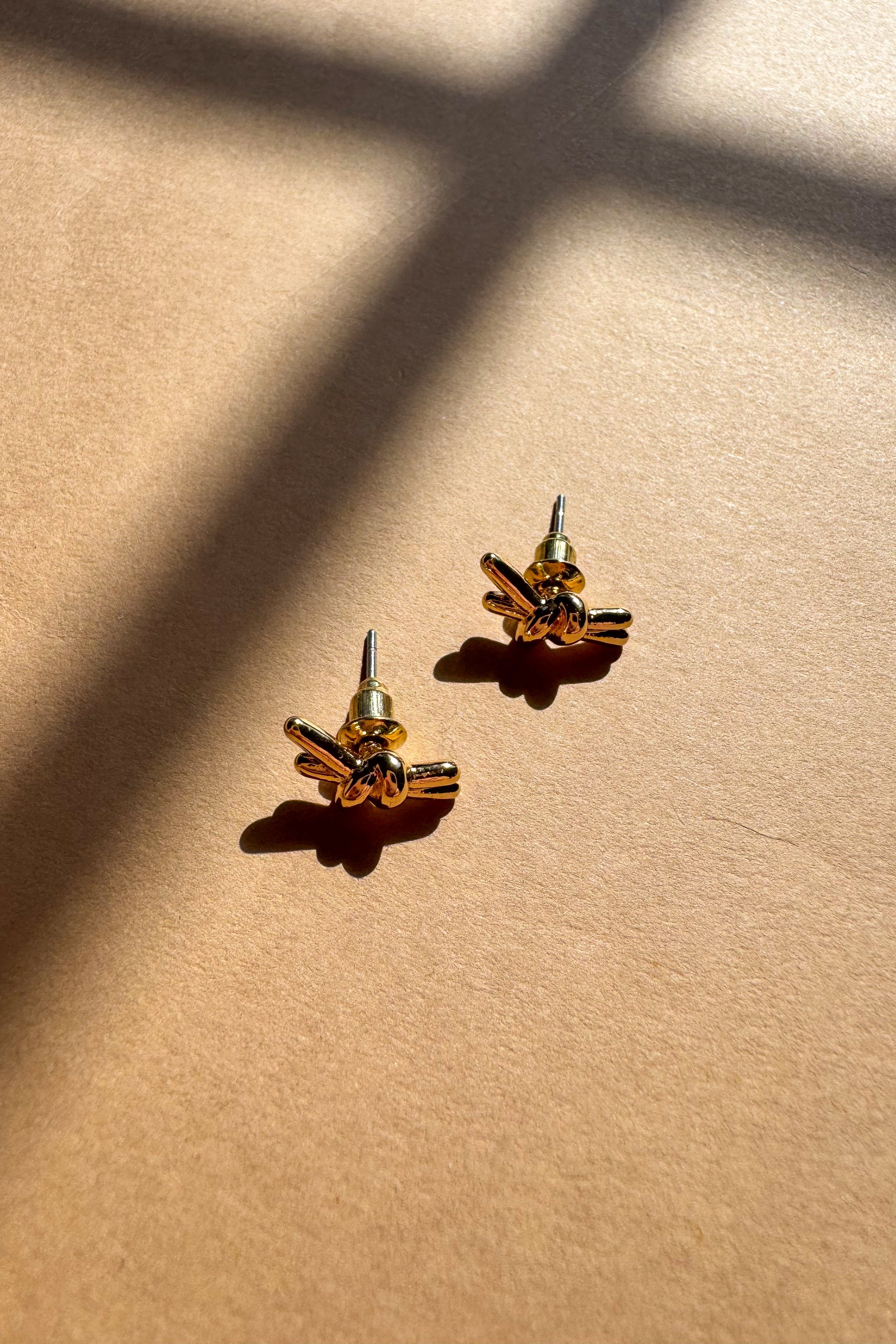 Ivy Gold Knot Stud Earrings - flat lay close up