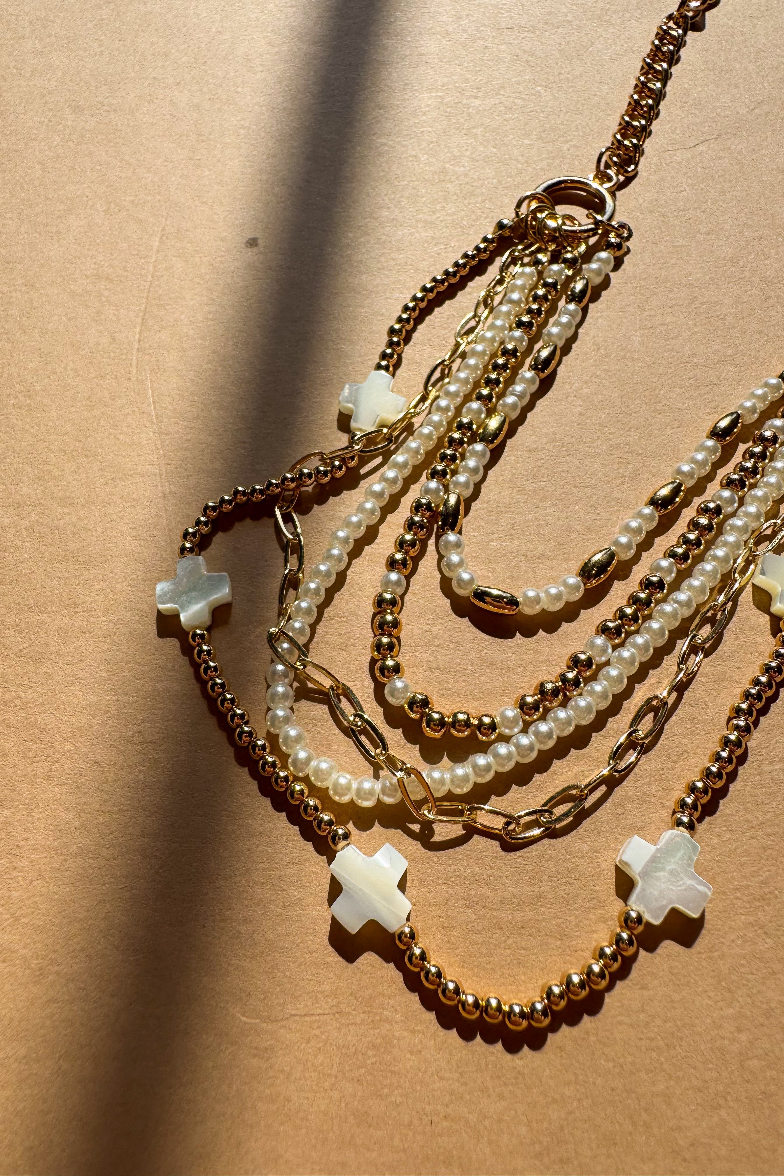 Nyla Gold & Pearl Layered Cross Necklace - close up flat lay