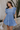 Full body view of model wearing the Nicole Blue Ruffle Short Sleeve Mini Dress which features chambray blue light weight fabric, mini length, chambray blue lining, two-tiered design, two side pockets, square neckline and ruffle short sleeves.