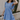 Side view of model wearing the Nicole Blue Ruffle Short Sleeve Mini Dress which features chambray blue light weight fabric, mini length, chambray blue lining, two-tiered design, two side pockets, square neckline and ruffle short sleeves.
