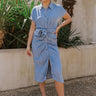 Full body view of model wearing the Addison Washed Denim Front Tie Midi Dress which features washed denim fabric, midi length, brown tortoise button up front closure, front cinch tie waist, collared neckline and short sleeves.