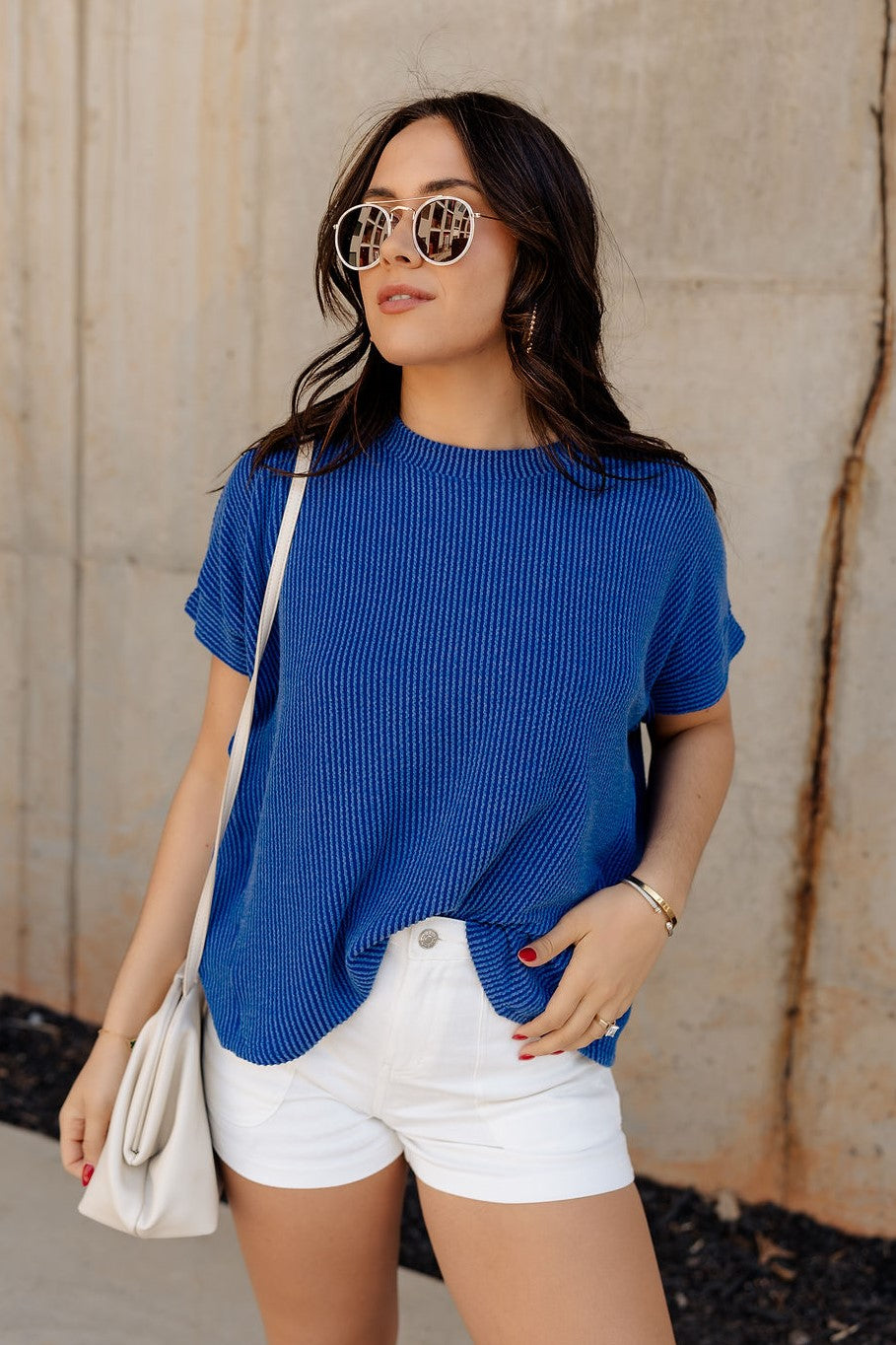 Front view of model wearing the Everly Blue Ribbed Short Sleeve Top that features dark blue and light blue contrast ribbing, a round neckline, and short dolman sleeves with ribbed cuff details. Shirt is front tucked.