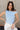 Front view of model wearing the Oakley Light Blue Sleeveless Top which features light blue knit fabic, cropped waist, scooped neckline, thick straps and sleeveless.