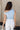 Back view of model wearing the Oakley Light Blue Sleeveless Top which features light blue knit fabic, cropped waist, scooped neckline, thick straps and sleeveless.