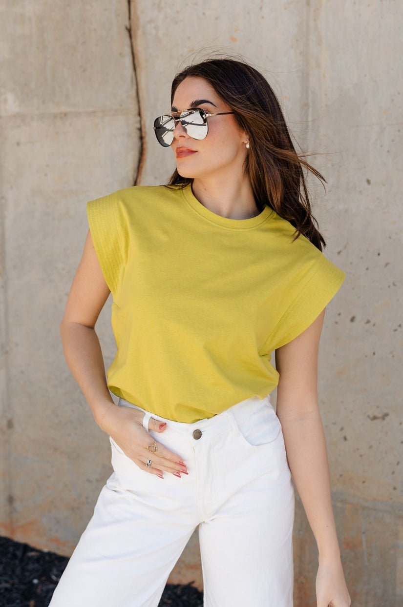 Front view of model wearing the Iris Chartreuse Sleeveless Top which features chartreuse cotton fabric, round neckline and short sleeves with stitch detail hem.