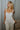 Front view of model wearing the Celeste Ivory V-Wire Sleeveless Jumpsuit which features ivory knit fabric, full-length ivory lining, a structured notched neckline, thick straps, side pockets, and wide legs.