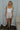 Full body view of model wearing the Juliette Cream Fray Shorts cream textured knit fabric, cream lining, fray hem details, two front pockets and front zipper with pearl button closure.