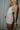 Side  view of model wearing the Juliette Cream Fray Shorts cream textured knit fabric, cream lining, fray hem details, two front pockets and front zipper with pearl button closure.