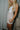 Side view of model wearing the Juliette Cream Fray Shorts cream textured knit fabric, cream lining, fray hem details, two front pockets and front zipper with pearl button closure.