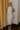 Full body view of model wearing the Elisya Cream Ruched Midi Dress which features cream sheen knit fabric, midi length, cream lining, slit on the side, ruched side details, high neckline and sleeveless.