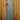 Full body view of model wearing the Cleo Green & White Halter Twist Midi Dress which features white and green lightweight fabric, geometric design, maxi length, halter twist neckline, sleeveless and open back with monochrome back zipper with hook closure.