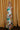 Full body view of model wearing the Alexandria Multi Abstract Halter Maxi Dress which features yellow, white, orange, green, and pink abstract print, cream full length lining, adjustable straps, a halter neckline with a tie, a low back, and a maxi length hemline.