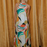 Full body view of model wearing the Alexandria Multi Abstract Halter Maxi Dress which features yellow, white, orange, green, and pink abstract print, cream full length lining, adjustable straps, a halter neckline with a tie, a low back, and a maxi length hemline.