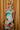 Front view of model wearing the Alexandria Multi Abstract Halter Maxi Dress which features yellow, white, orange, green, and pink abstract print, cream full length lining, adjustable straps, a halter neckline with a tie, a low back, and a maxi length hemline.